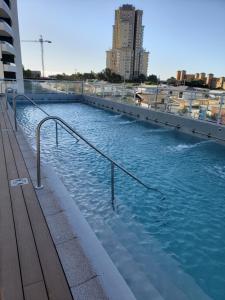 einen Pool mit blauem Wasser in einer Stadt in der Unterkunft DEPARTAMENTO EDIFICIO MARES DE MONTEMAR in Concón