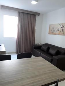 a living room with a table and a couch at Caldas Novas Riviera in Caldas Novas