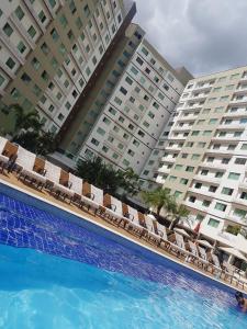 a hotel swimming pool with chairs and a hotel at Caldas Novas Riviera in Caldas Novas