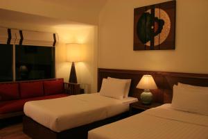 a hotel room with two beds and a couch at Palita Lodge - SHA Plus in Haad Rin