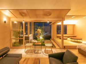 een woonkamer met een bed en een tafel en stoelen bij Hotel Nagasaki in Nagasaki