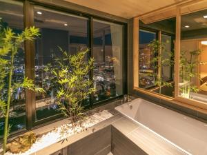 a bath tub in a bathroom with a view of a city at Hotel Nagasaki in Nagasaki