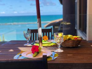 a wooden table with a plate with a knife and fork on it at Cobertura Barra de São Miguel in Barra de São Miguel