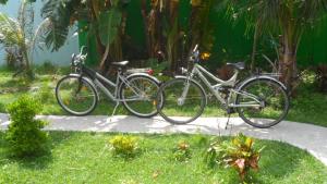 two bikes parked on a sidewalk in the grass at Ferienhaus am Strand von Sibuyan in der Nähe von Cresta de Gallo in San Fernando