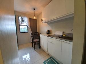a small kitchen with white cabinets and a table at 409 El Montalvo Bldg San Jose Residencias in Santa Rosa