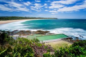 a tennis court on a beach next to the ocean at BIG4 Happy Hallidays in Hallidays Point