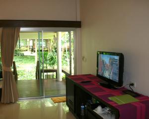 a living room with a flat screen tv on a table at Palita Lodge - SHA Plus in Haad Rin