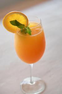 un vaso de zumo de naranja con una rodaja de naranja en Impossible Cliff House, en Uluwatu