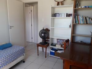 um quarto com uma cama e uma estante de livros em Apartamento aconchegante em Recife