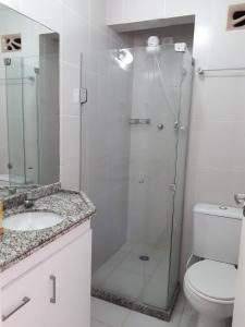 a bathroom with a shower with a toilet and a sink at Apartamento aconchegante in Recife