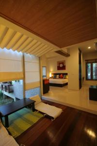 a living room with a couch and a bed at Palita Lodge - SHA Plus in Haad Rin