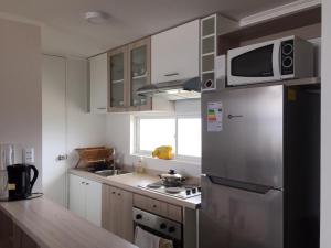 a kitchen with a stainless steel refrigerator and a microwave at Refugio los molles in Los Molles