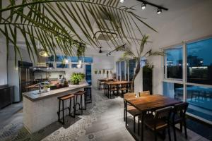 Color Coral Boutique Hotel في ماغونغ: مطبخ وغرفة طعام مع طاولات وكراسي