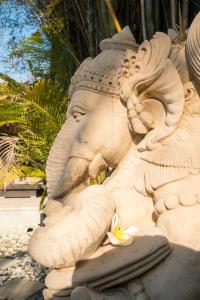 a stone statue of an elephant with flowers on it at Seminyak Villa in Seminyak