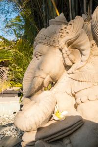 eine steinerne Statue eines Elefanten mit Blumen darauf in der Unterkunft Seminyak Villa in Seminyak
