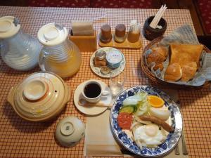 una mesa con una bandeja de alimentos para el desayuno y café en Hayashi Pension, en Hakuba