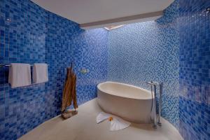 a blue tiled bathroom with a tub in it at Kutus Kutus Mas Ubud Villa in Ubud