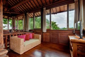 パヤンガンにあるVilla Atas Awanの籐の椅子と窓のあるポーチでスクリーン