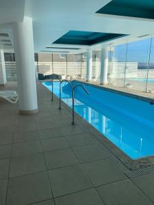 una piscina con acqua blu in un edificio di Departamento Nuevo con vista al mar, amoblado a Concón