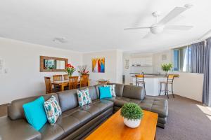 
a living room filled with furniture and a couch at Rainbow Commodore Apartments in Gold Coast
