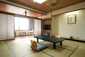 a living room with a ping pong table in it at Miyajima Hotel Makoto in Miyajima