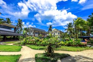 a house with a garden and palm trees at Retreat Siargao Resort in General Luna