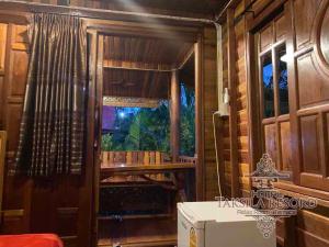 Zimmer mit Fenster in einem Holzhaus in der Unterkunft Taksila Resort ฏักร์ศิลารีสอร์ท in Ban Nong Lup