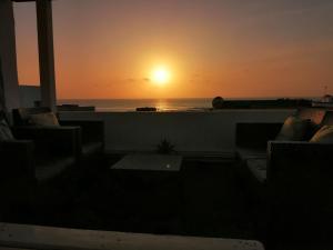 zachód słońca nad oceanem z balkonu z kanapami w obiekcie Apartamentos Flor del Cotillo w mieście Cotillo