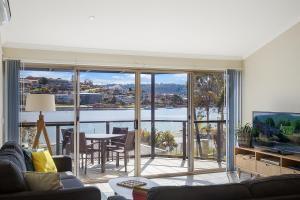 a living room with a view of the water at Sails Luxury Apartments Merimbula in Merimbula