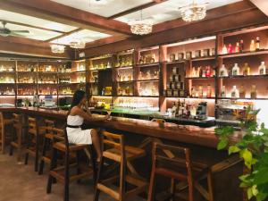 a woman sitting at a bar in a restaurant at Retreat Siargao Resort in General Luna