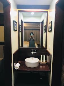 a woman taking a picture of a sink in a bathroom at Retreat Siargao Resort in General Luna
