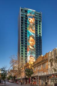 a tall building with a large clock on it's side at Art Series - The Adnate in Perth