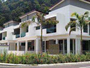 a white building with palm trees in front of it at Pangkor 88 Villa Jia Yuan 邦咯岛家苑海滩度假别墅 in Kampong Pasir Bogak