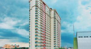 a tall white building with many windows on it at Nawasena Studio at Solo Paragon Apartment in Solo
