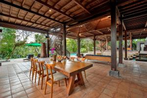 - une salle à manger avec une table et des chaises en bois dans l'établissement Villa Atas Awan, à Payangan