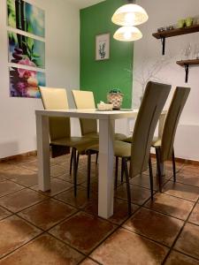 a dining room table with green chairs and a white table at Apartments Banovci in Banovci