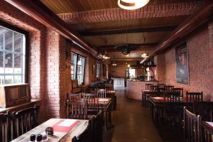 restauracja z drewnianymi stołami i krzesłami oraz ceglaną ścianą w obiekcie Penzion u Trávníčka w mieście Modřice