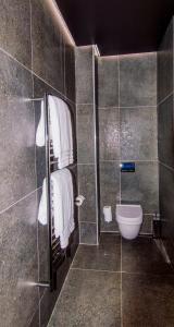 een badkamer met een douche, een toilet en handdoeken bij De Haas Living @ Die Laan 2 in Stellenbosch
