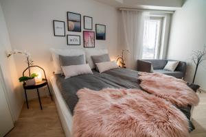 ein Schlafzimmer mit einem großen Bett mit einer Pelzmütze in der Unterkunft New & luxurious apartment SUPERIOR by Arctic Homes in Rovaniemi