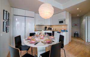 ein Esszimmer mit einem weißen Tisch und Stühlen in der Unterkunft New & luxurious apartment SUPERIOR by Arctic Homes in Rovaniemi