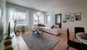 ein Wohnzimmer mit einer weißen Couch und einem Tisch in der Unterkunft New & luxurious apartment SUPERIOR by Arctic Homes in Rovaniemi