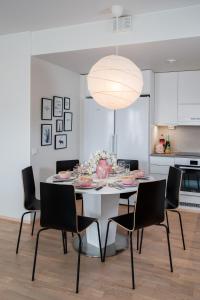 ein Esstisch mit Stühlen und einer großen Leuchte in der Unterkunft New & luxurious apartment SUPERIOR by Arctic Homes in Rovaniemi + 37 Fotos