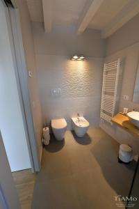 a bathroom with a toilet and a bidet at TiAMo Modern Design Guest House in Ronchi dei Legionari