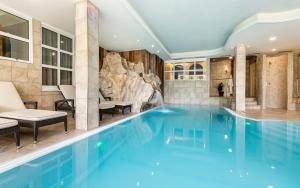 ein Pool in einem Hotel mit einer Felswand in der Unterkunft Familienhotel Viktoria in Ulten