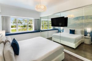 
a hotel room with a bed, television, and entertainment center at Penguin Hotel in Miami Beach
