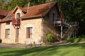 2 chaises assises devant une maison en pierre dans l'établissement Gîte dans un Domaine Historique, à Chevreuse