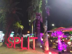 a sign that says spin in front of palm trees at night at Split studio Irisha in Split