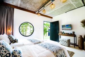 a bedroom with two beds and a window at Body Factory Bali in Canggu