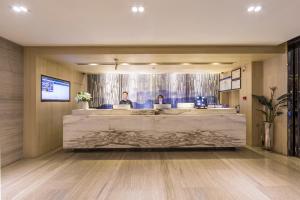 a lobby with two people sitting at a reception desk at Atour Hotel Xi'an (Wenjing Road, North 2nd Ring Road in Xi'an