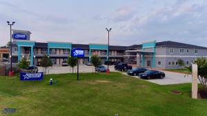 a large building with cars parked in a parking lot at Americas Best Value Inn Houston Willowbrook in Houston +9 photos